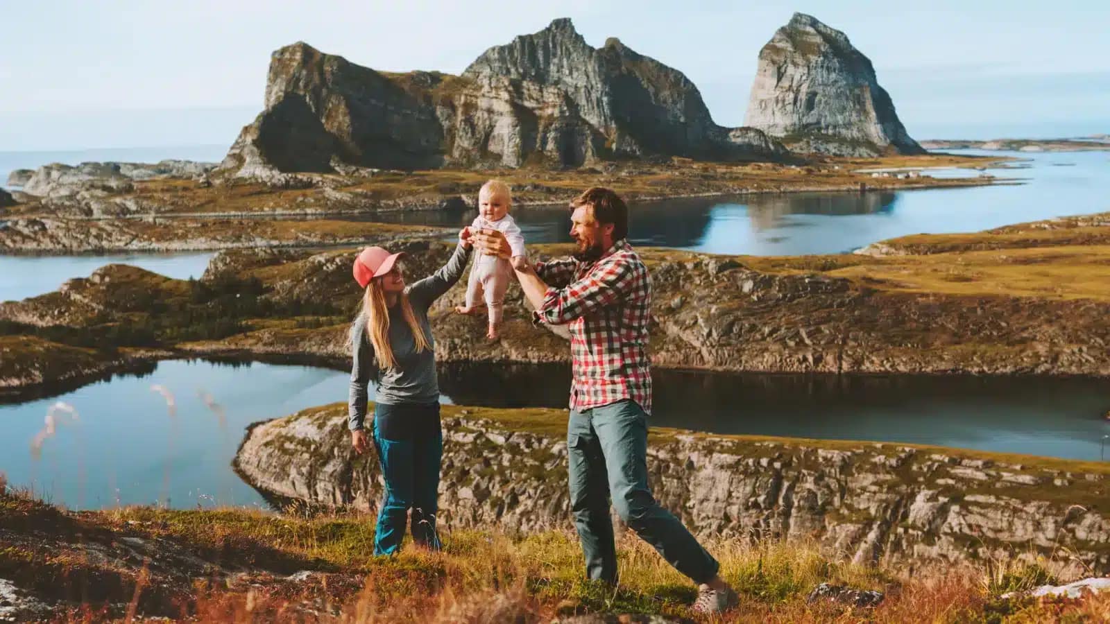 Family with a baby on the rocky coast of the Helgeland islands, Norway