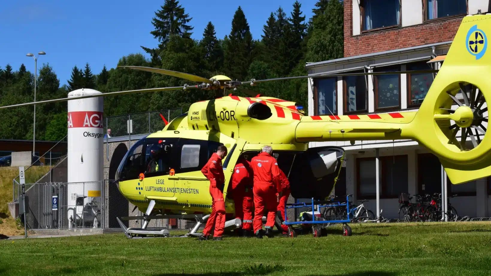Norwegian air ambulance crew at a helicopter outside a hospital building