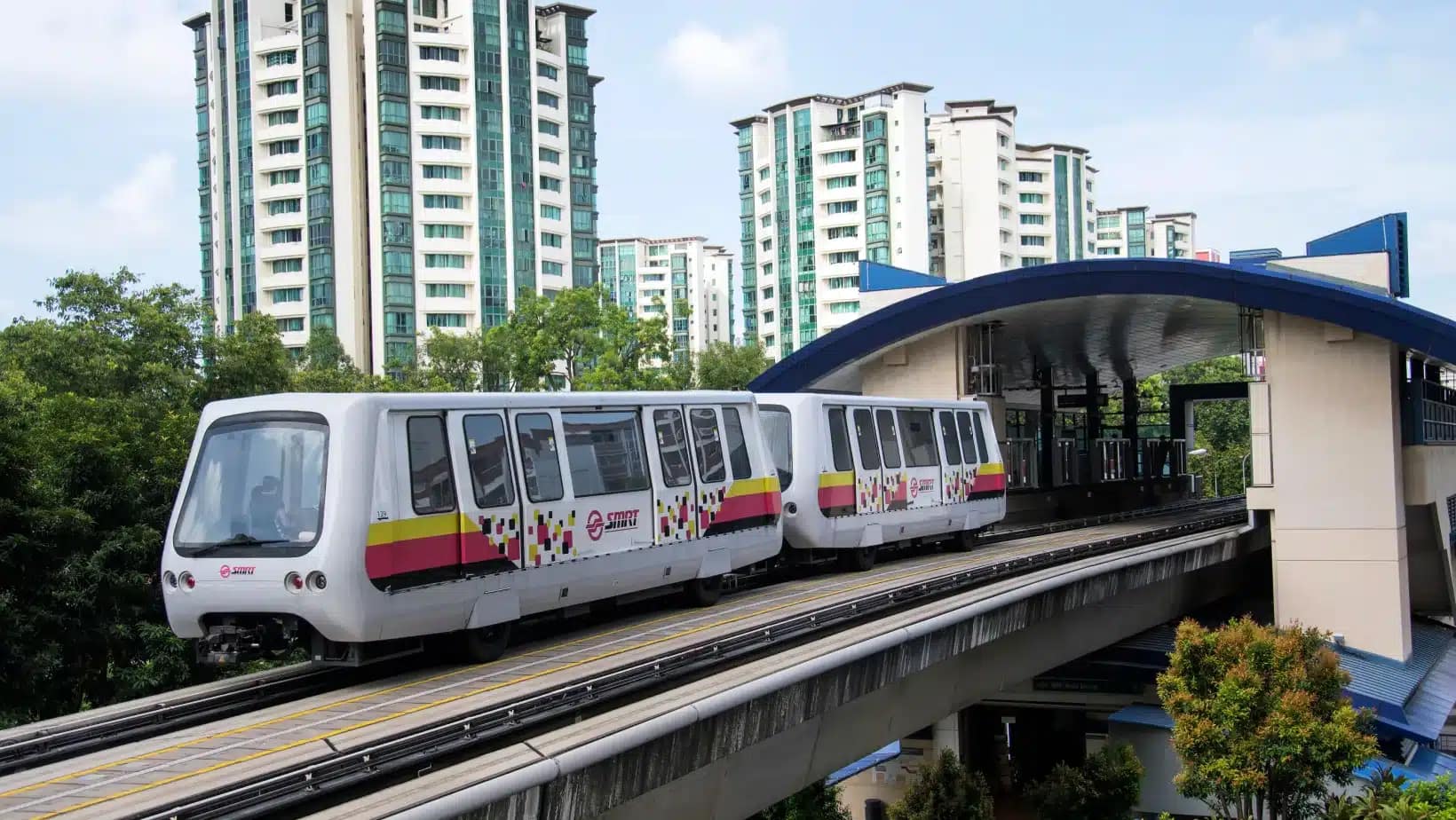 A light rail train passing apartment towers in Singapore