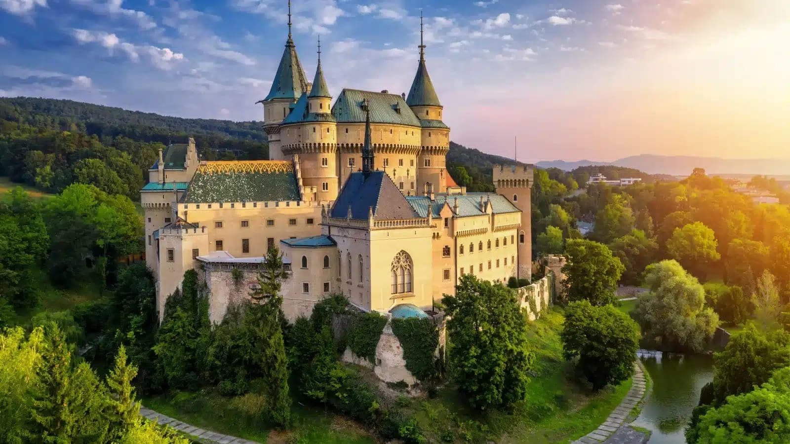 A hilltop castle above the forests of the Slovak countryside at sunset