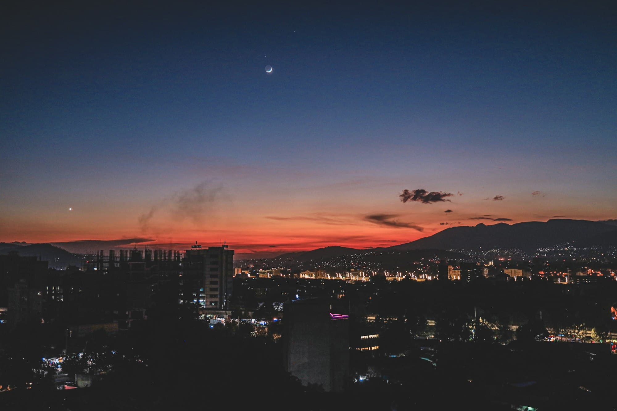 The Addis Ababa skyline at dusk with hills behind the city lights