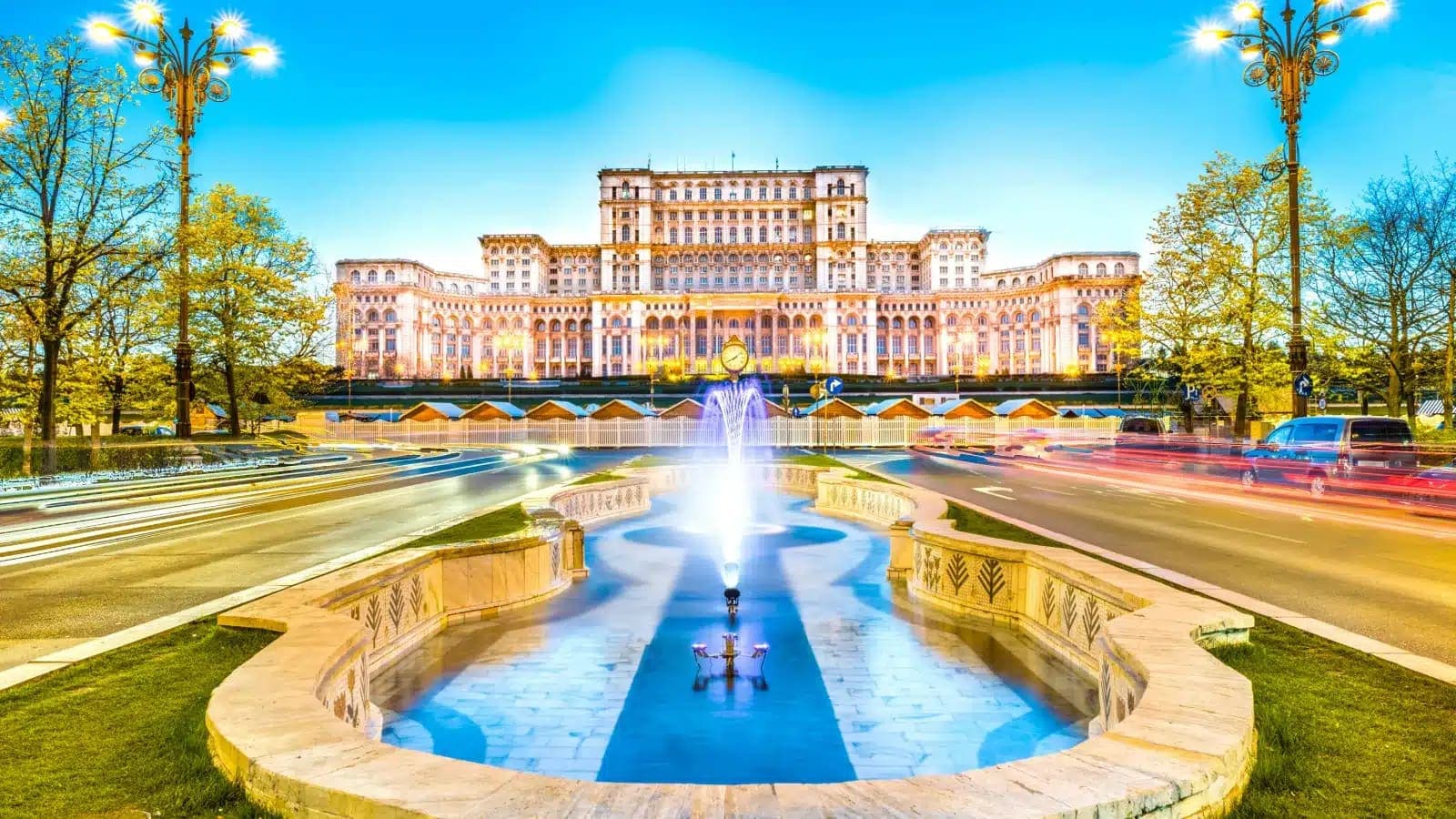 Palace of the Parliament in Bucharest behind a fountain at dusk