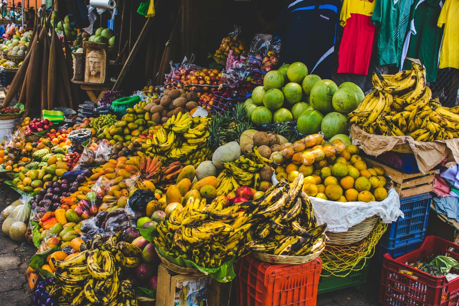 Piles of bananas, melons and citrus at a market stall in Antigua Guatemala