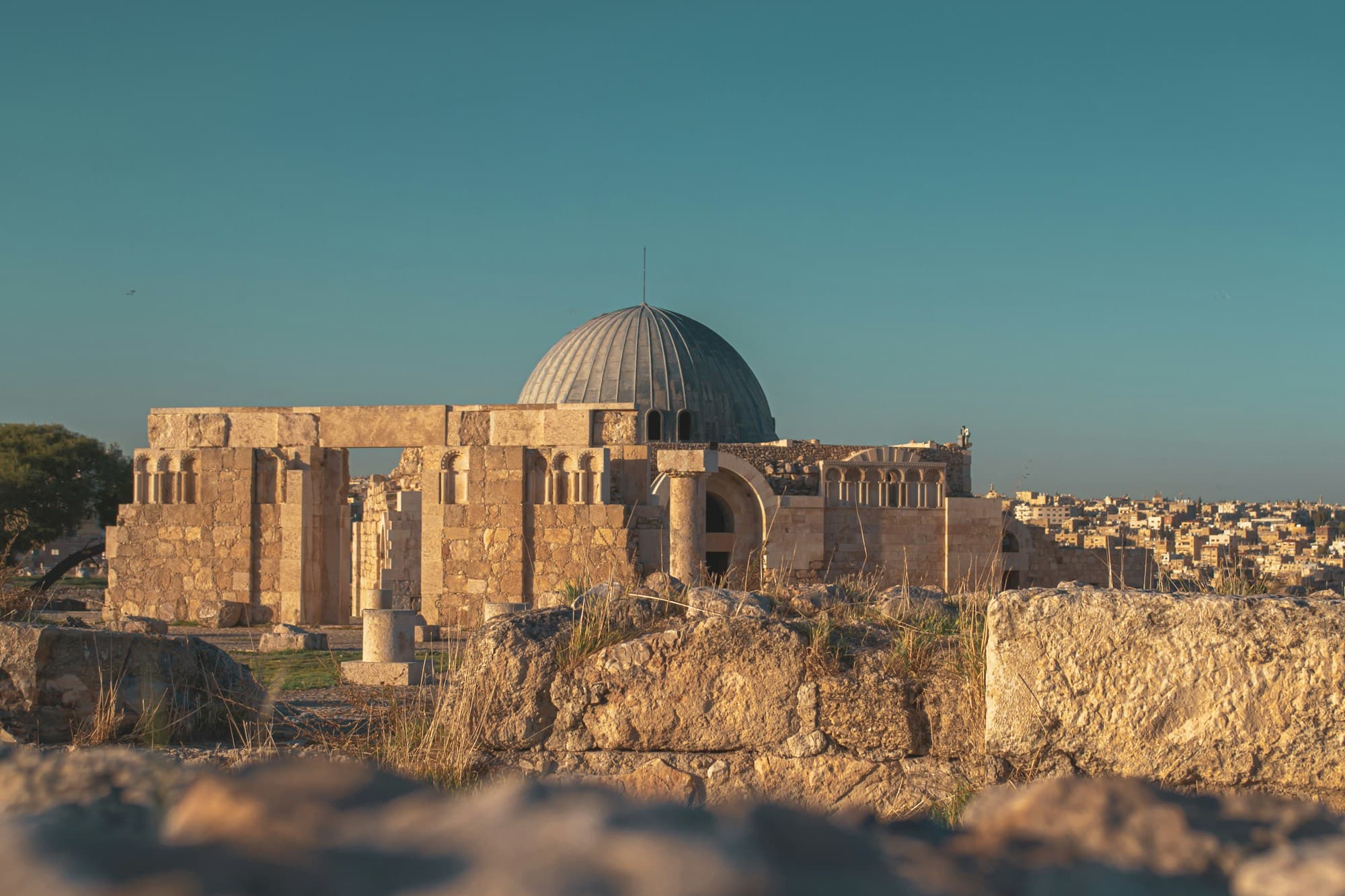 The Umayyad Palace dome on the Amman Citadel at sunset with the city behind