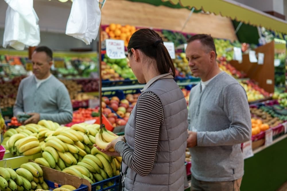Couple picking bananas at a neighborhood produce market