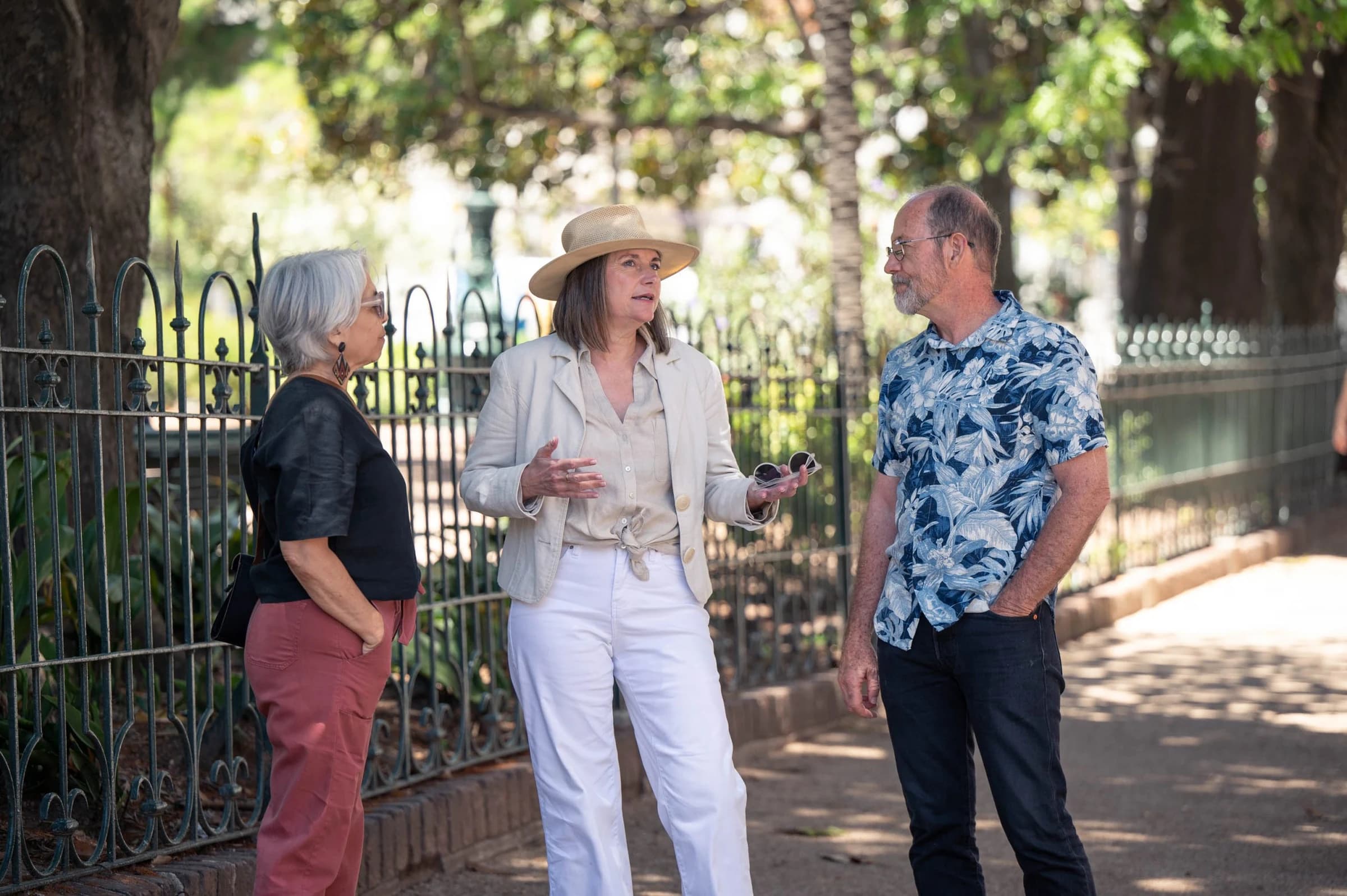 Karen of Guru Guay talking with two clients on a tree-lined street in Uruguay
