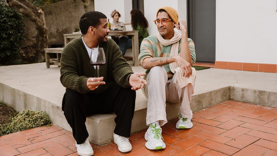 Two attendees chatting with a glass of wine